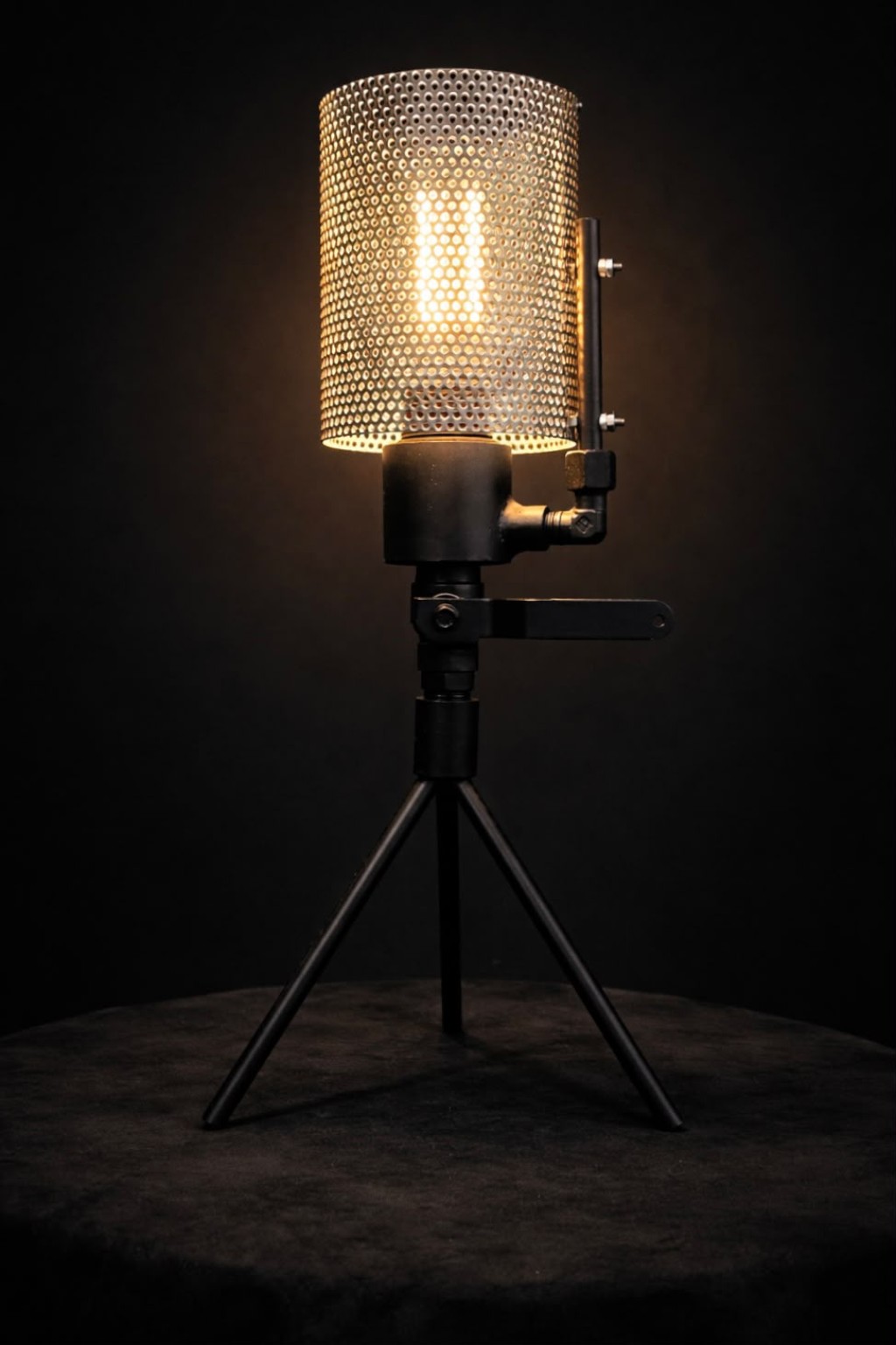 Perforated metal light on a three-legged stand